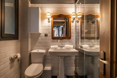 a bathroom with two sinks and a toilet and a mirror at Stay U-nique Apartments Pou in Barcelona