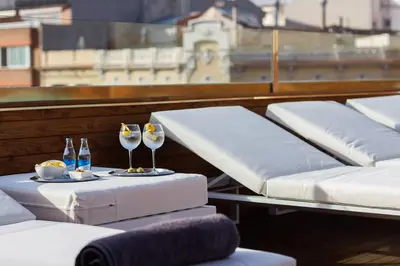 a row of beds with wine glasses on a balcony at Hotel Well and Come Barcelona in Barcelona