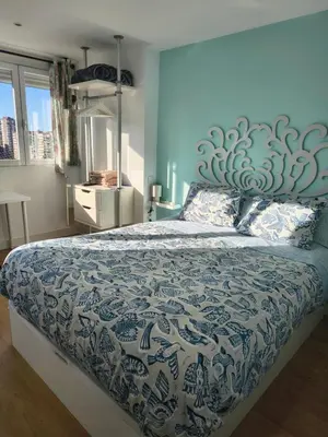a bedroom with a large bed with a blue wall at Fira Gran Via & Aeropuerto Barcelona Mi Colibrí in Hospitalet de Llobregat