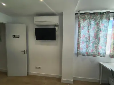 a room with a heater and a television on the wall at Fira Gran Via & Aeropuerto Barcelona Mi Colibrí in Hospitalet de Llobregat