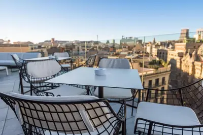 a table and chairs on a balcony with a view at Negresco Princess 4* Sup in Barcelona