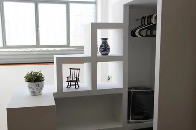 a room with a shelf with a chair and a vase at Loft Sant Martí - Glories in Barcelona