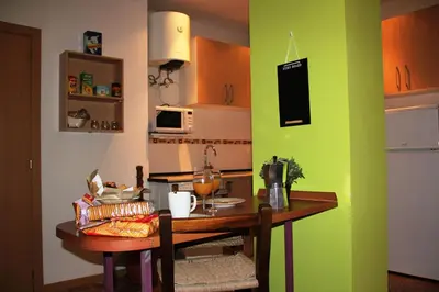 a kitchen with a table and a green wall at Loft Sant Martí - Glories in Barcelona