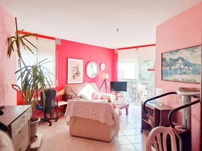 a living room with red walls and a couch at Apartamento a 5 minutos del centro y playa in Sitges