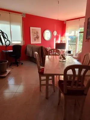 a dining room with red walls and a table and chairs at Apartamento a 5 minutos del centro y playa in Sitges