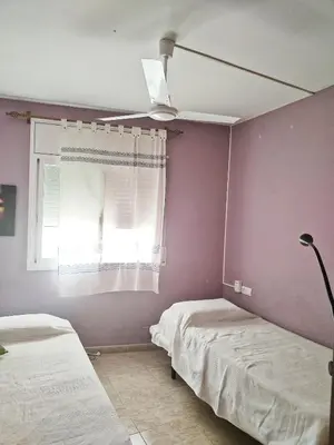 a bedroom with two beds and a ceiling fan at Apartamento a 5 minutos del centro y playa in Sitges