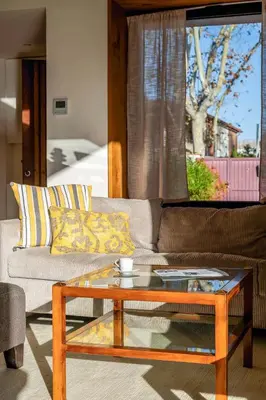 a living room with a couch and a coffee table at Canela Homes COSTA LA PINEDA in Castelldefels