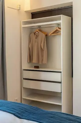a closet with a jacket and a shirt in it at Canela Homes COSTA LA PINEDA in Castelldefels
