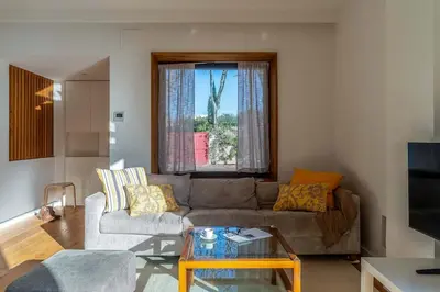 a living room with a couch and a table at Canela Homes COSTA LA PINEDA in Castelldefels