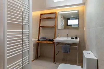 a bathroom with a sink and a mirror and a toilet at Canela Homes COSTA LA PINEDA in Castelldefels