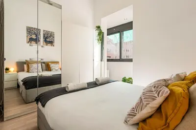 a bedroom with a large bed and a mirror at Stylish Apartment with Balcony in Central Barcelona in Barcelona