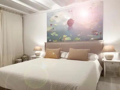 a bedroom with a bed with a large painting on the wall at Key White in Barcelona