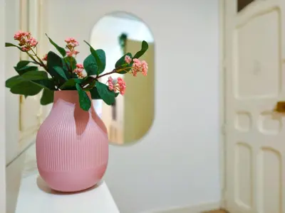 a pink vase with a plant sitting on a table at Apartamento turístico Muntaner Bonanova Sarrià in Barcelona