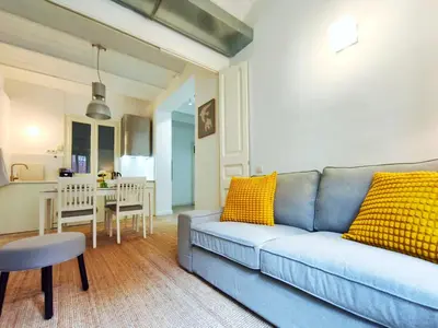 a living room with a blue couch and yellow pillows at Apartamento turístico Muntaner Bonanova Sarrià in Barcelona