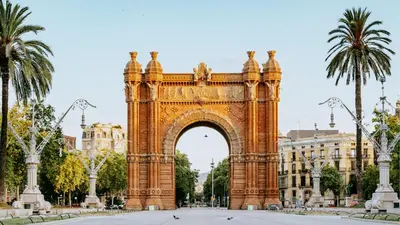 an arch in front of a building with palm trees at Design Apartment in Barcelona in Barcelona