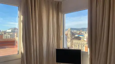 a room with a large window with a television in it at Ático premium Rambla Catalunya - Terraza 50 m2 in Barcelona