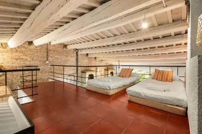 two beds in a room with a brick wall at Gràcia Loft Terrace BBQ AC & Fiber Wi-Fi in Barcelona