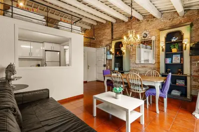 a living room and dining room with a brick wall at Gràcia Loft Terrace BBQ AC & Fiber Wi-Fi in Barcelona