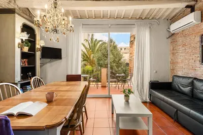 a living room with a table and a couch at Gràcia Loft Terrace BBQ AC & Fiber Wi-Fi in Barcelona