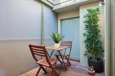 a table and chairs on a balcony with plants at Cozy Apartment III - Les Corts in Barcelona
