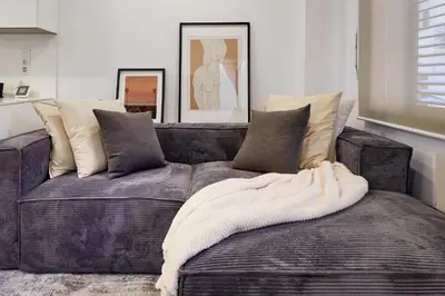 a living room with a couch with a blanket on it at Cozy Apartment III - Les Corts in Barcelona