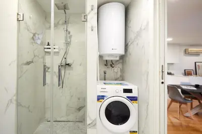 a bathroom with a washing machine and a shower at Cozy Apartment III - Les Corts in Barcelona