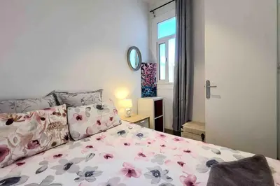 a bedroom with a bed with pink flowers on it at Central apartment in Barcelona in Barcelona