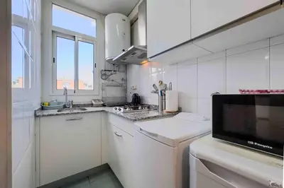 a white kitchen with a sink and a microwave at Central apartment in Barcelona in Barcelona