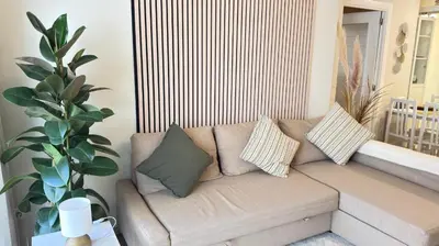 a couch in a living room with pillows on it at Entire Apartment in Barcelona, Camp Nou, Les Corts in Barcelona