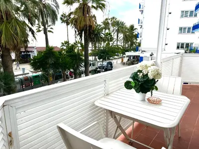 a white table with a vase of flowers on a balcony at Sitges Seafront RIBERA in Sitges
