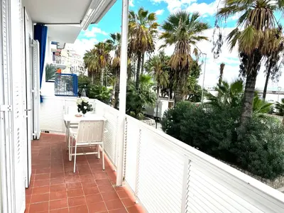 a balcony with a table and palm trees on it at Sitges Seafront RIBERA in Sitges