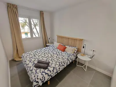 a bedroom with a bed and a table and a window at Lovely apartment Poblenou beach in Barcelona