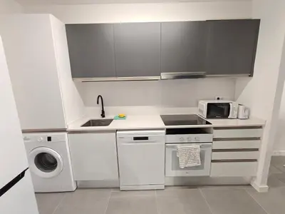 a white kitchen with a sink and a microwave at Lovely apartment Poblenou beach in Barcelona