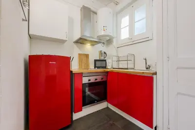 a kitchen with red cabinets and a red refrigerator at Apartamento de 3 habitaciones en Barcelona in Hospitalet de Llobregat