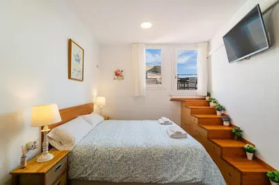 a bedroom with a bed and a television and stairs at Downtown penthouse with views of Barcelona in Barcelona
