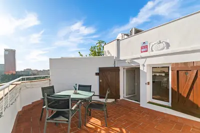 a patio with a table and chairs on a balcony at Downtown penthouse with views of Barcelona in Barcelona