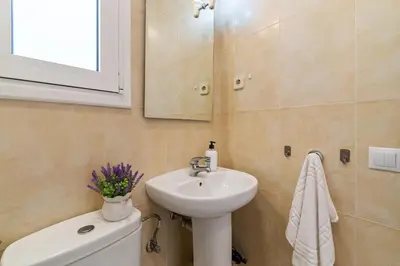 a bathroom with a sink and a toilet and a mirror at Downtown penthouse with views of Barcelona in Barcelona
