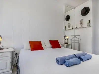 a white bed with red and blue pillows on it at Apartment Xaloc by Interhome in Cubelles