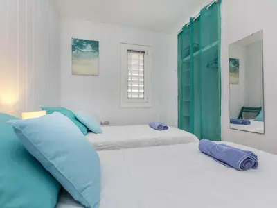 a bedroom with two beds with blue pillows at Apartment Xaloc by Interhome in Cubelles