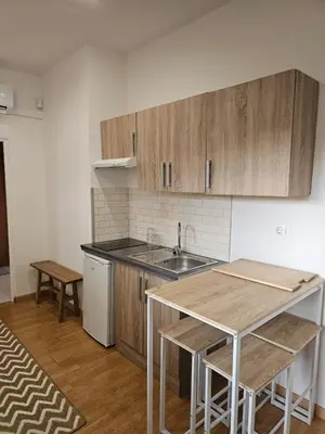 a kitchen with wooden cabinets and a sink and a table at La Casa Delviga in Can Trabal
