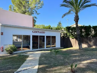 a white building with a palm tree in front of it at La Casa Delviga in Can Trabal