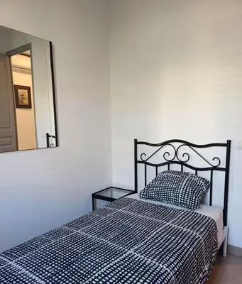 a bedroom with a bed with a black and white comforter and a mirror at Barcelona Eixample - Sagrada Familia - Monumental - City Center in Barcelona
