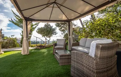 a gazebo with chairs and an umbrella on a lawn at Gorgeous Home In Arenys De Munt in Arenys de Munt
