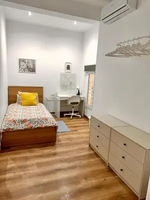a bedroom with two beds and a desk and a tv at Habitación 3 Metro Sant Antoni in Barcelona