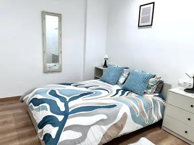 a bedroom with a bed with a blue and white comforter at Habitación 5 Sant Pau in Barcelona