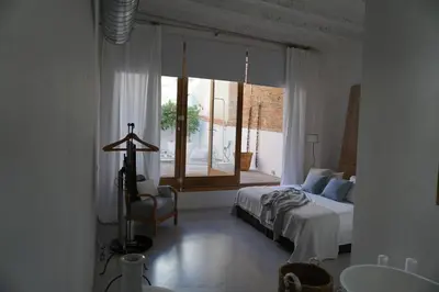 a bedroom with a bed and a window and a chair at Born penthouse loft 1 in Barcelona