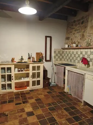 a kitchen with white cabinets and a tile floor at Antic Can Poi - Masia histórica del siglo XIII en la Garriga in La Garriga