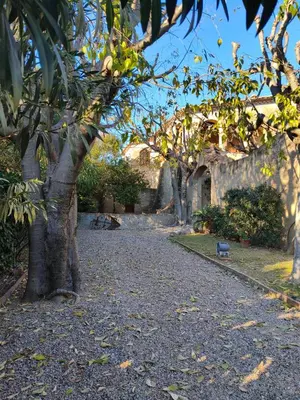 a gravel road with trees and a building at Antic Can Poi - Masia histórica del siglo XIII en la Garriga in La Garriga