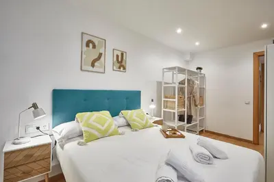 a bedroom with a large white bed with a blue headboard at BBarcelona Guinardó Park in Barcelona