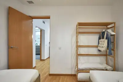 a bedroom with two bunk beds and a room with a door at BBarcelona Guinardó Park in Barcelona